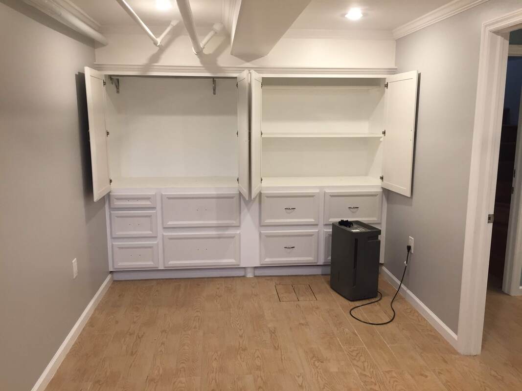Room finished with white built-in cabinets and open shelving