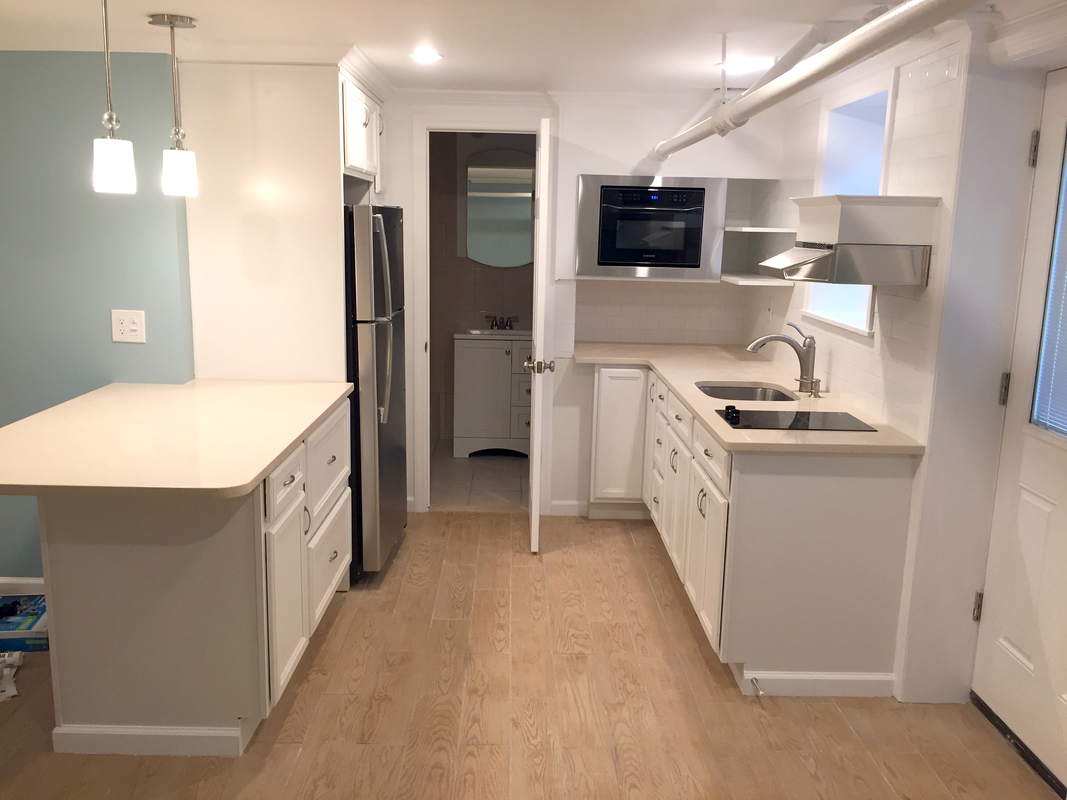 Kitchen with white cabinets, stainless appliances and new flooring